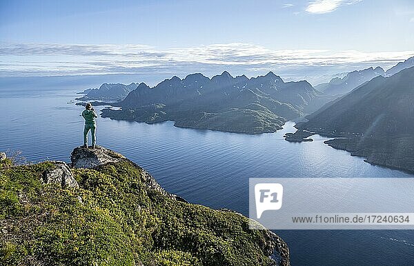 Junge Wanderin blickt auf Bergpanorama  Fjord Raftsund und Berge  Blick vom Gipfel des Dronningsvarden oder Stortinden  Vesterålen  Norwegen  Europa