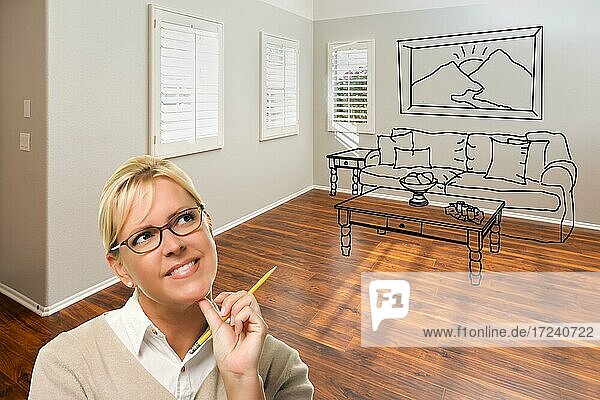 Woman with pencil in empty room of new house with couch and table drawing on wall