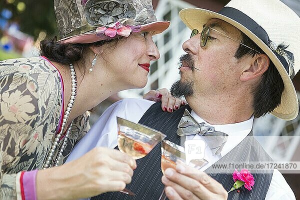 Attraktives gemischtrassiges Paar  gekleidet in der Mode der 1920er Jahre  schlürft Champagner