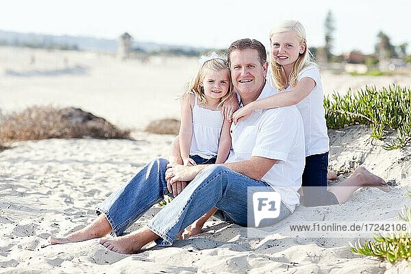 Gutaussehender Papa und seine niedlichen Töchter Porträt am Strand