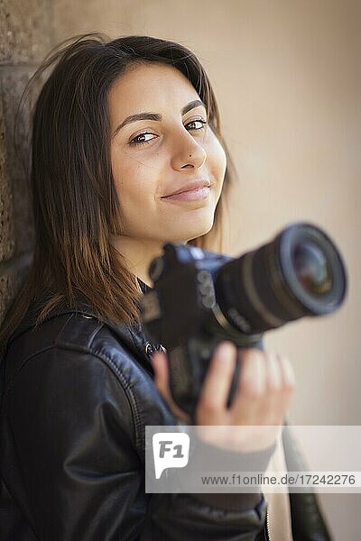 Attraktive gemischtrassige junge Fotografin hält Kamera  Portrait