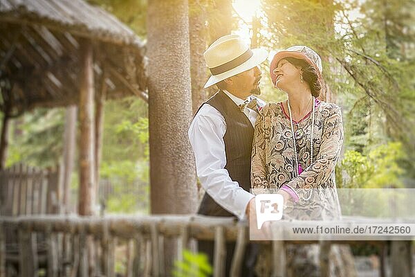 Attraktives romantisches Paar gekleidet nach der Mode der 1920er Jahre auf Holzbrücke