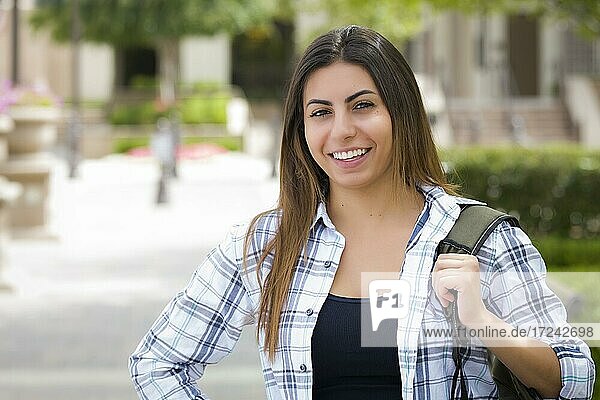 Attraktive junge multiethnische Studentin  Porträt auf dem Schulcampus mit Rucksack