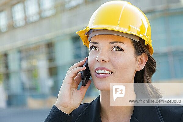 Junge Frau mit Helm auf Baustelle mit Handy  Architektin  Bauleiterin