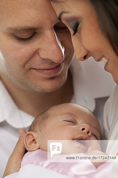 Happy young attractive mixed-race couple with newborn baby