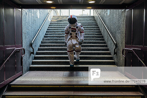 Male astronaut moving down from stairs