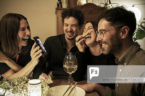 Freundinnen lachen während eines Videoanrufs über das Mobiltelefon zu Hause
