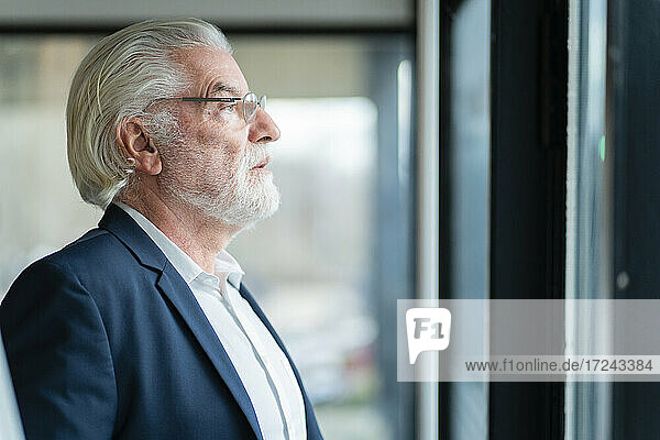 Senior male entrepreneur looking away at office