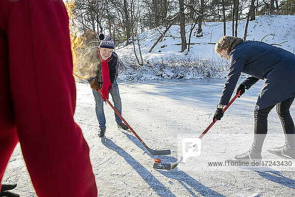 Älterer Mann spielt im Winter mit Freunden Eishockey im Schnee