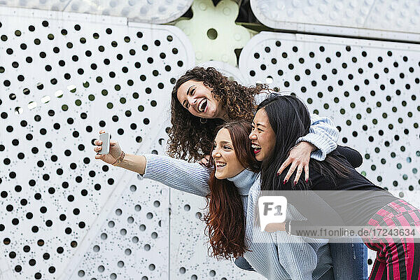 Verspielte Frauen nehmen Selfie auf Handy zusammen