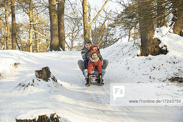 Family sledding on snow during winter