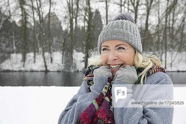 Fröhliche Frau in warmer Kleidung im Park im Winter