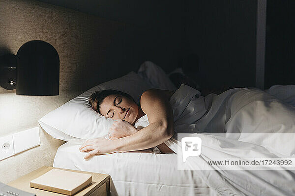 Schöne Frau schläft auf dem Bett im Hotelzimmer