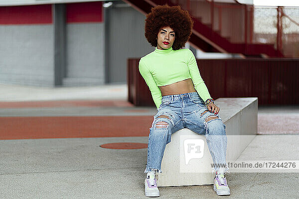 Afro-Frisur Frau sitzt auf Bank