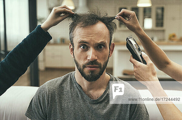 Verwirrter Mann beim Haarschnitt zu Hause