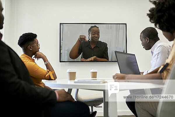 Unternehmerin gestikuliert während einer Videokonferenz im Büro