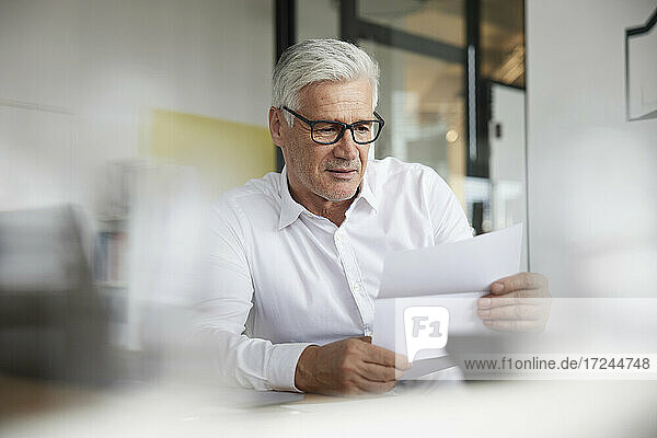 Businessman reading document in office