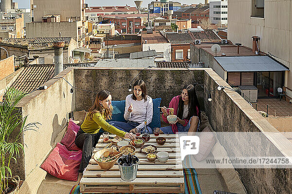 Female friends eating food on rooftop