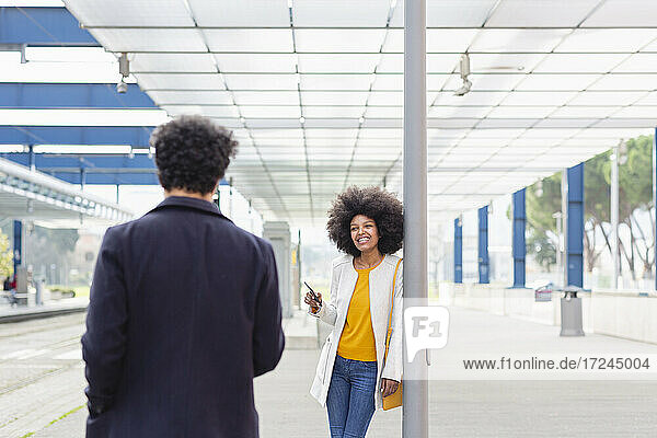 Afro-Frau sieht männlichen Freund am Bahnhof an