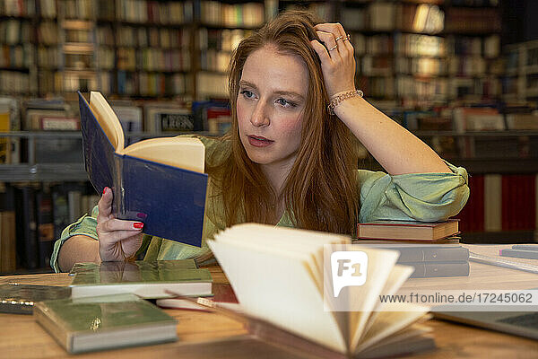 Schöne Frau liest Buch in Bibliothek