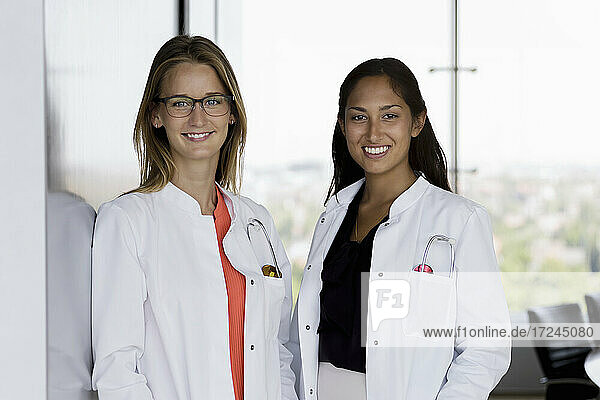 Lächelnde Ärztinnen stehen zusammen im Krankenhaus