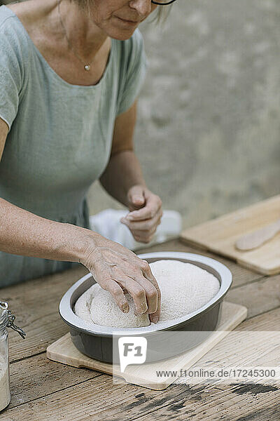 Ältere Frau prüft gebackenen Teig im Hinterhof