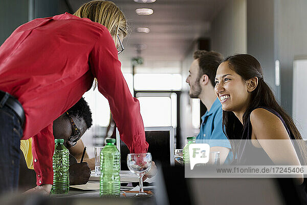 Lächelnde männliche und weibliche Fachkräfte arbeiten im Sitzungssaal im Büro