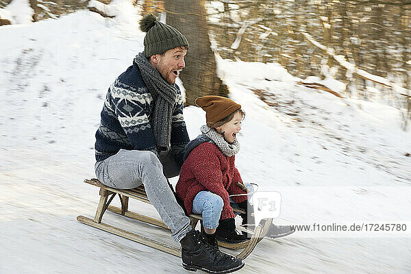 Father and son sledding during winter