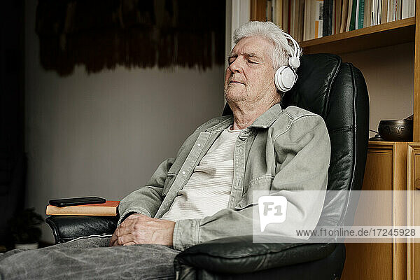 Relaxed senior man wearing headphones at home