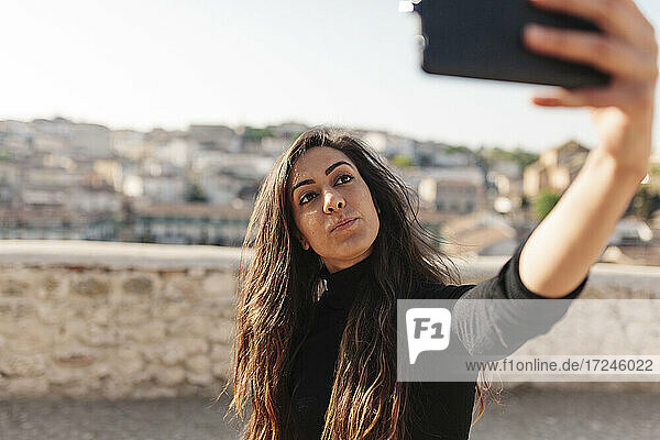 Frau nimmt Selfie durch Smartphone an einem sonnigen Tag