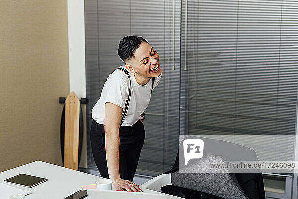 Fröhliche Geschäftsfrau an einem Tisch im Büro