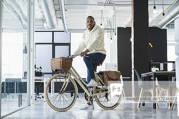 Geschäftsmann auf dem Fahrrad im Coworking-Büro