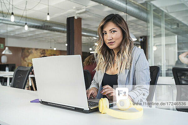 Businesswoman working on laptop at coworking office