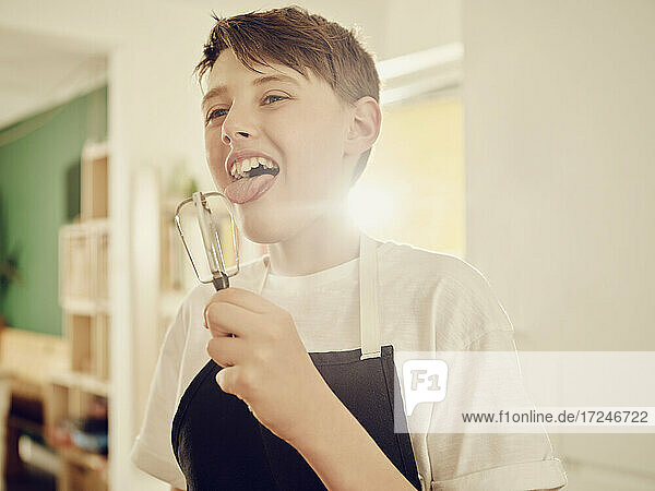 Junge leckt Klopfer in der Küche zu Hause