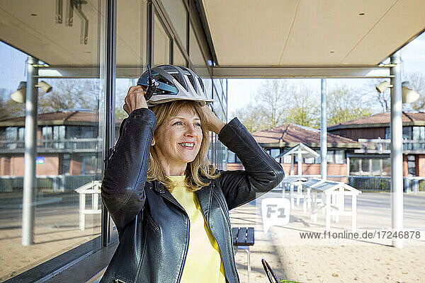 Smiling woman wearing sports helmet during sunny day