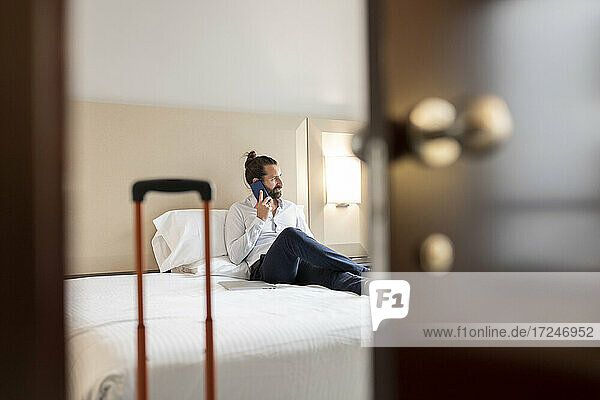 Man talking on mobile phone at hotel suite