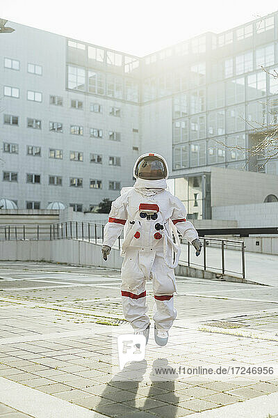 Astronautin in der Luft in der Nähe eines Gebäudes an einem sonnigen Tag