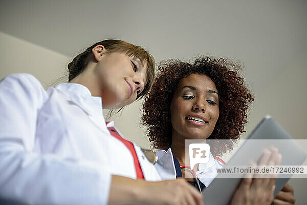Ein Team von weiblichen Fachkräften diskutiert über ein digitales Tablet im Krankenhaus