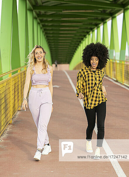 Freundinnen gehen auf einer Brücke im Freien
