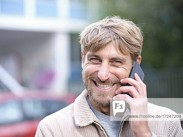 Smiling man talking on smart phone