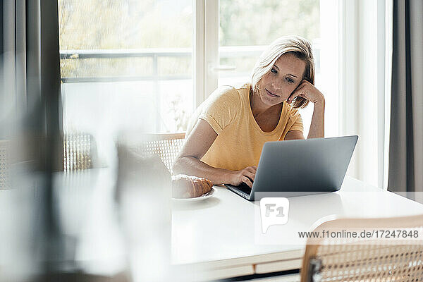 Female entrepreneur using laptop at home