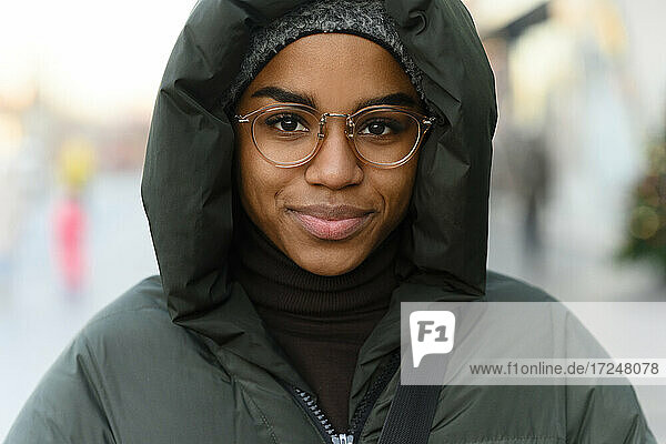 Smiling woman in eyeglasses wearing warm clothing