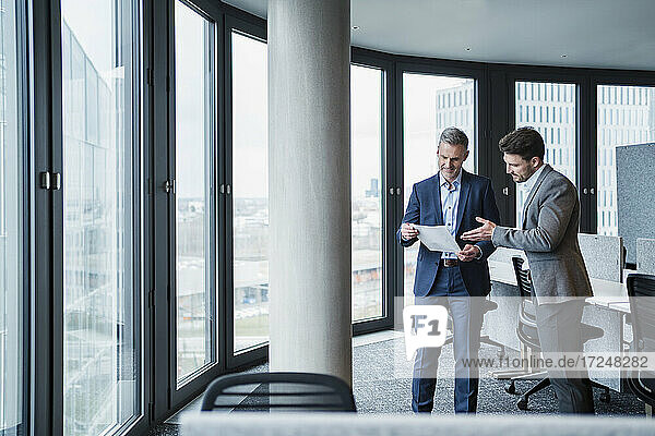 Business people discussing over paper document in meeting at work place