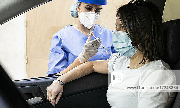 Frau erhält COVID-19-Impfstoff im Auto am Drive-In