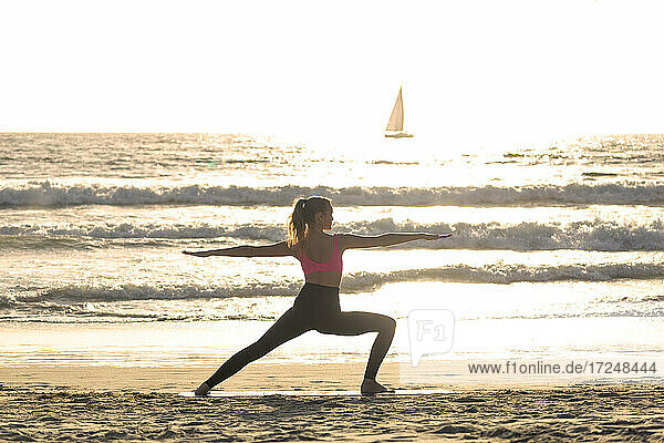 Junge Frau beim Sport am Strand an einem sonnigen Tag