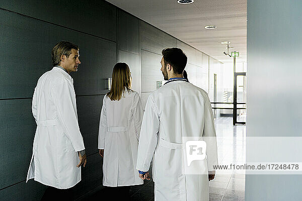 Male and female doctors walking in corridor at hospital