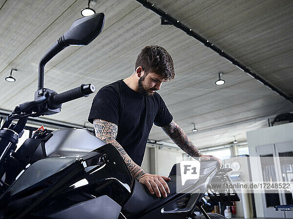 Expert checking motorcycle seat at repair shop