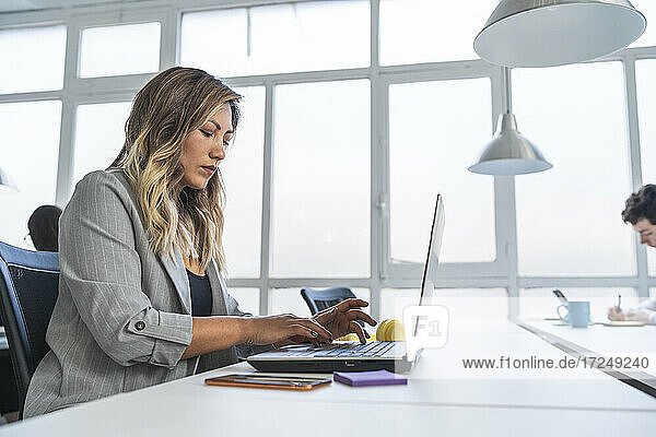 Geschäftsfrau arbeitet am Laptop am Schreibtisch im Coworking-Büro