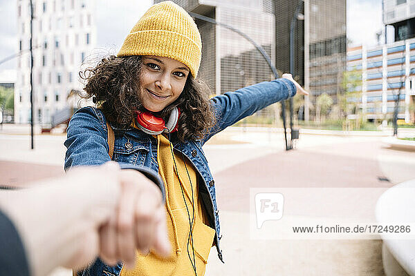 Junge Frau hält die Hand eines Freundes in der Stadt