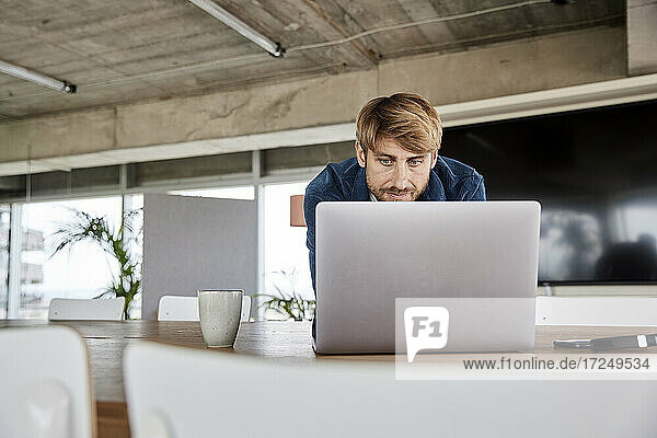 Blonder Mann benutzt Laptop im Loft